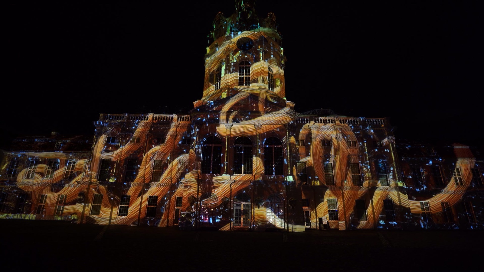 The façade of Charlottenburg Palace in Berlin covered in a red and white ornamental projection mapping during the Festival of Lights