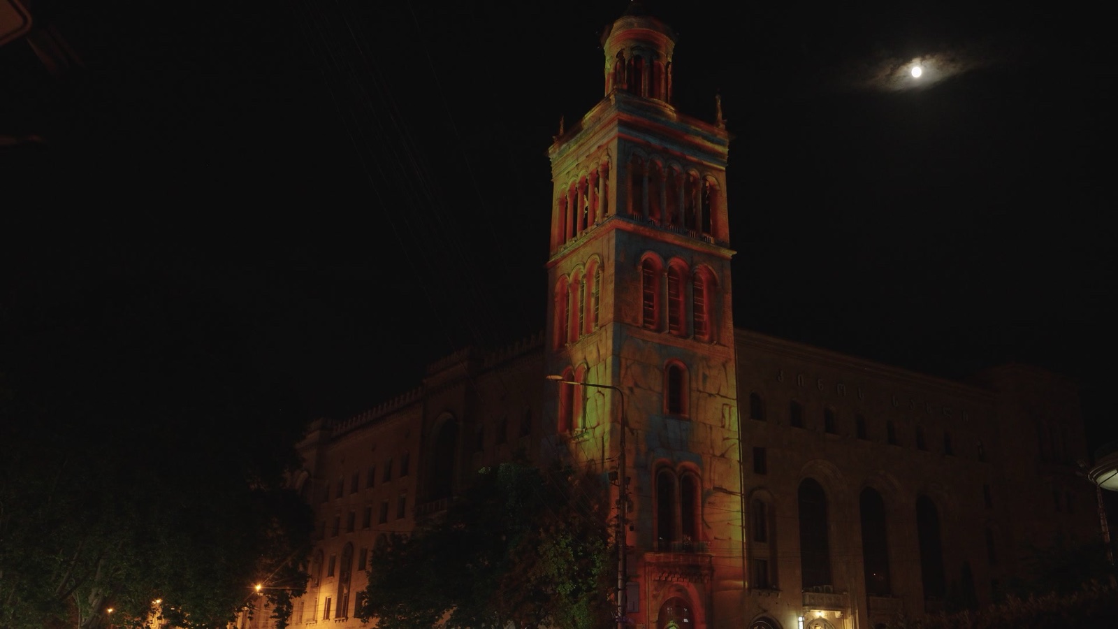 The tower of the Georgian National Academy of Sciences on Rustaveli Avenue in Tbilisi covered in a colourful projection mapping at night