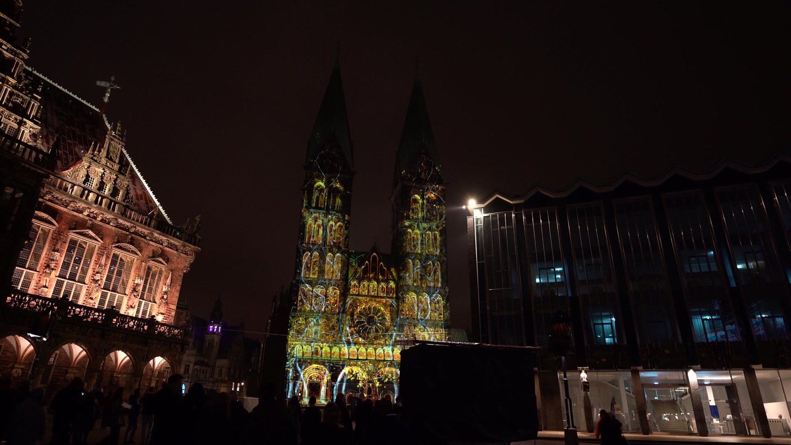 The twin towers of Bremen Cathedral illuminated in blue and gold by a 3D projection mapping at night