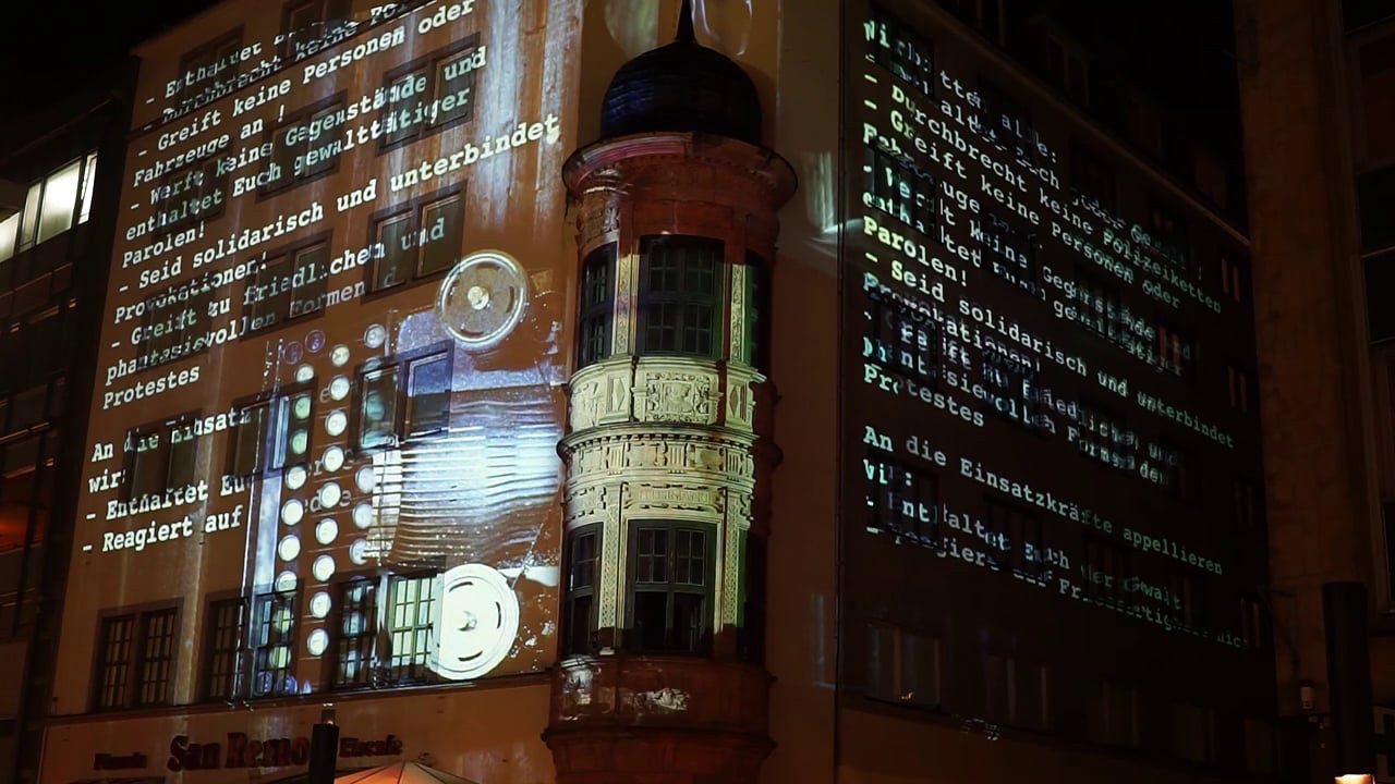 Historic documents and typewritten text projected onto a façade in Leipzig during the Lichtfest