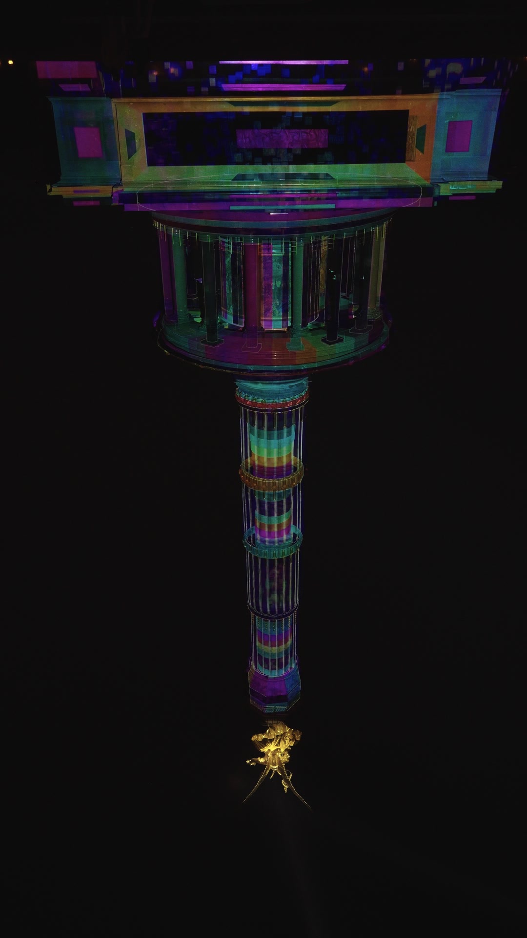 The Berlin Victory Column wrapped in a rainbow-coloured 360-degree projection mapping at night, filmed from below